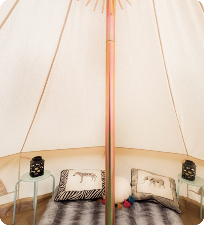 Tent with bed, pillows, and  on tables